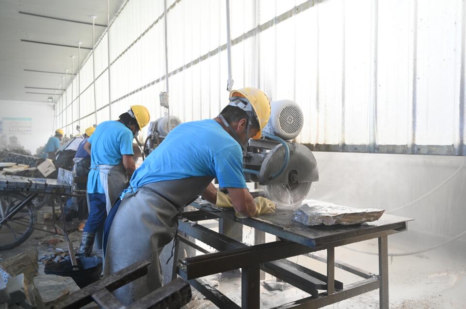 Skilled workers in a busy cutting workshop with tools and materials.