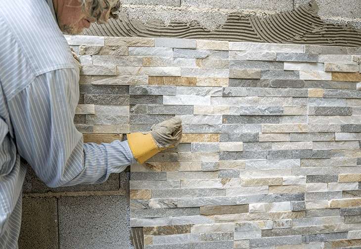 Interior and exterior stacked stone wall being cleaned and maintained