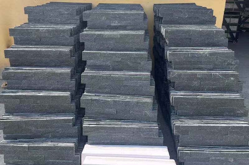 A comparison of natural stacked stone and manufactured stone panels showing texture and color differences