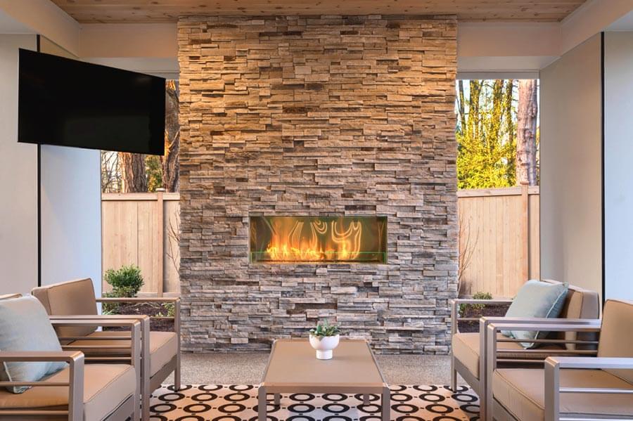 A modern stacked stone fireplace enhancing a living room interior with warm tones and texture