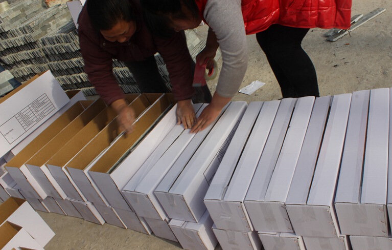 Cartons containing stacked stone tiles ready for shipping and delivery